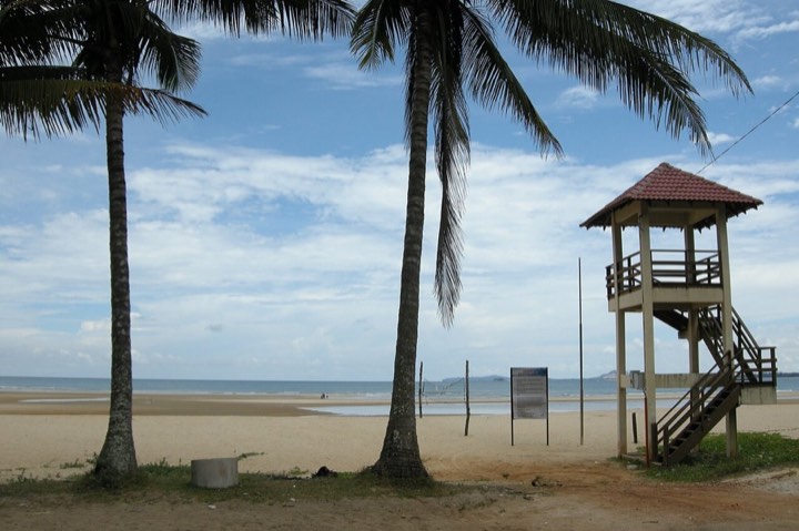 Pantai Cherating dengan pokok kelapa dan menara pemerhati